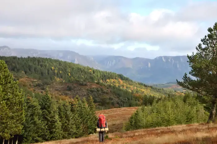 Randonneur en balade sur un chemin de randonnée pédestre face massif du Caroux